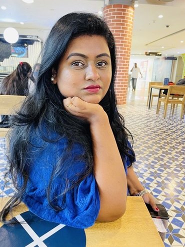 Sandhya sitting in blue dress